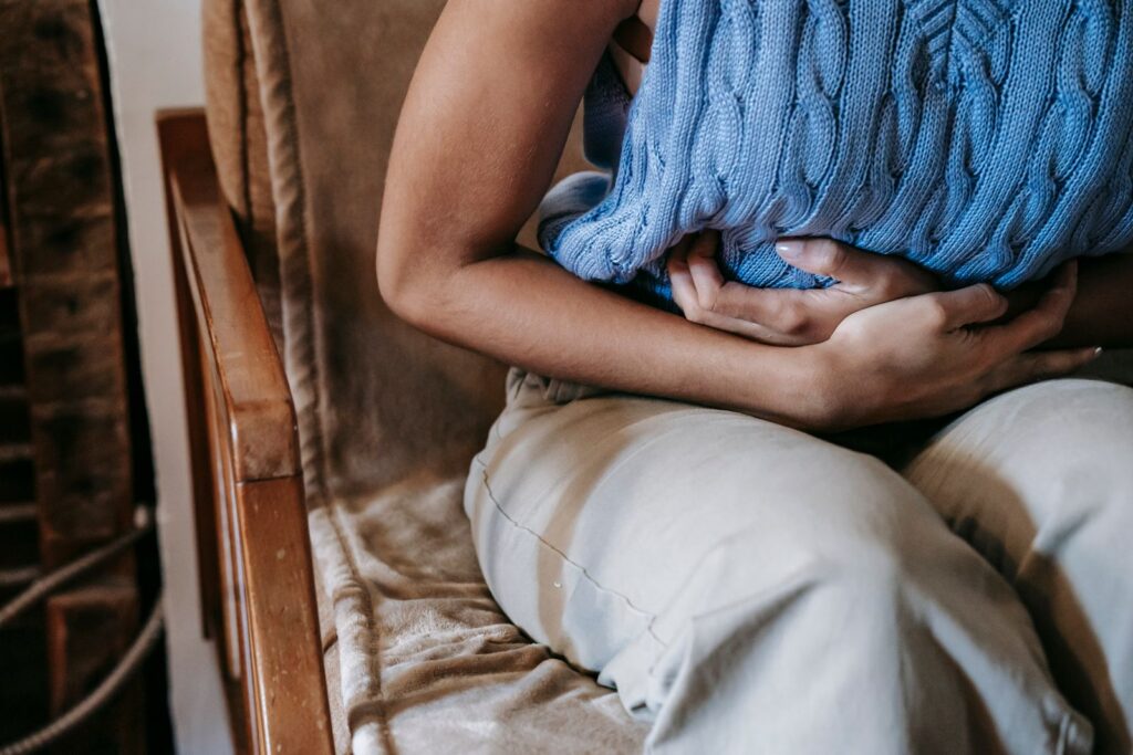 Persoon met buikpijn houdt de hand op de buik, illustratie bij ADHD en maag-darmklachten